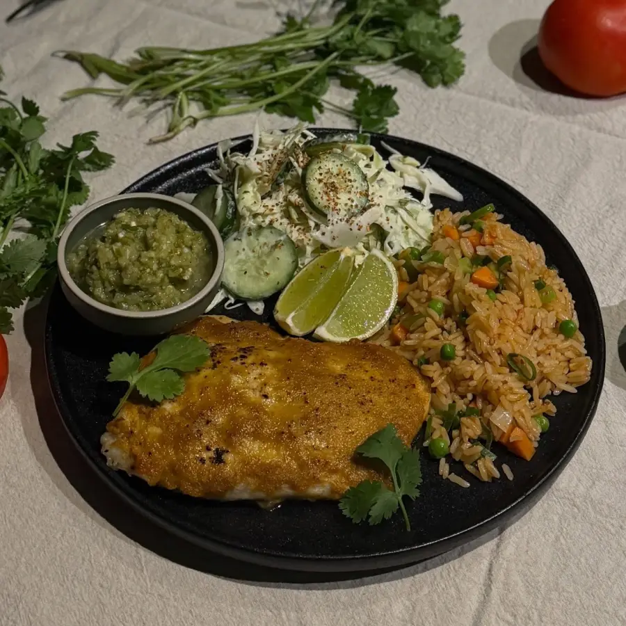 Mexican-style fish served with rice, slaw, salsa and lime